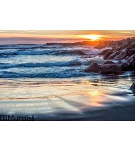 Sunset at rocky ocean jetty Wall Mural