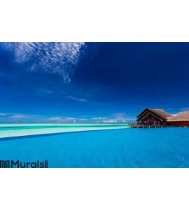 Infinity pool over tropical lagoon with blue sky Wall Mural